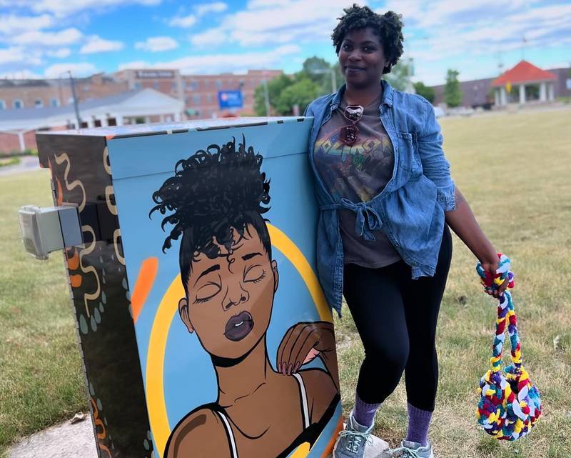 Artist Aaliyah Steele visits the utility box mural created with her artwork at Lincoln Highway and Fourth Street in DeKalb.