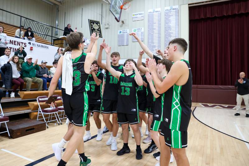 Bishop McNamara players celebrate with the Watseka Holiday Tournament championship plaque following the Fightin' Irish's 62-41 victory over Clifton Central on Tuesday, Dec. 16, 2025.