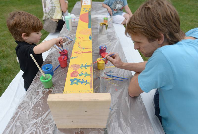Luke Harm and his dad Mike of Downers Grove help paint the community peace pole during the Unplug Illinois Day held at the Downers Grove Park District Saturday July 8, 2023.