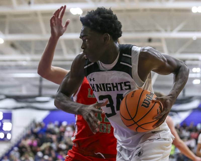 Kaneland's Jeffrey Hassan (34) drives baseline during their Plano Christmas Classic semi-final basketball game between Kaneland at LaSalle Peru Monday, Dec 29, 2025 in Plano.