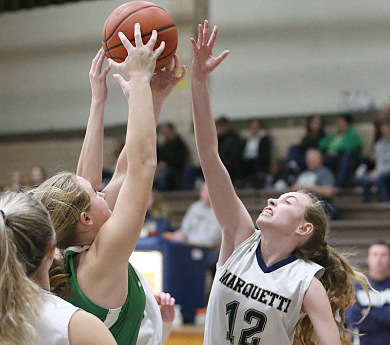Seneca's Tessa Krull grabs a rebound over Marquette's Lily Craig in Bader Gym on Monday, Jan. 23, 2023 at Marquette High School.