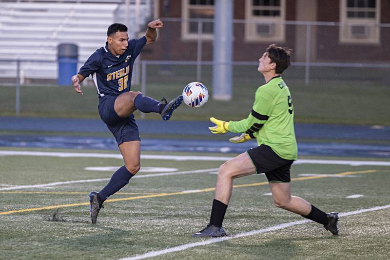 Sterling’s Felipe Sandoval tips the ball over against Lasalle-Peru goalkeeper Jacob Gross Tuesday, Oct. 17, 2023 in a regional semifinal in Sterling. It was Sandoval’s third goal of the first half.