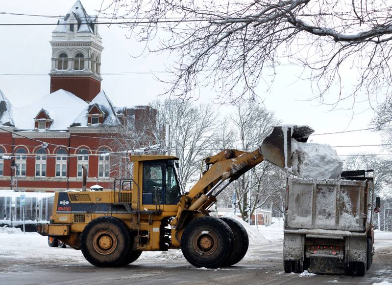 Workers for Benesh & Sons, contracted by the City of Oregon, were busy Saturday clearing snow from the downtown. Snow was plowed into piles and then scooped into trucks to. be hauled outside the city limits.