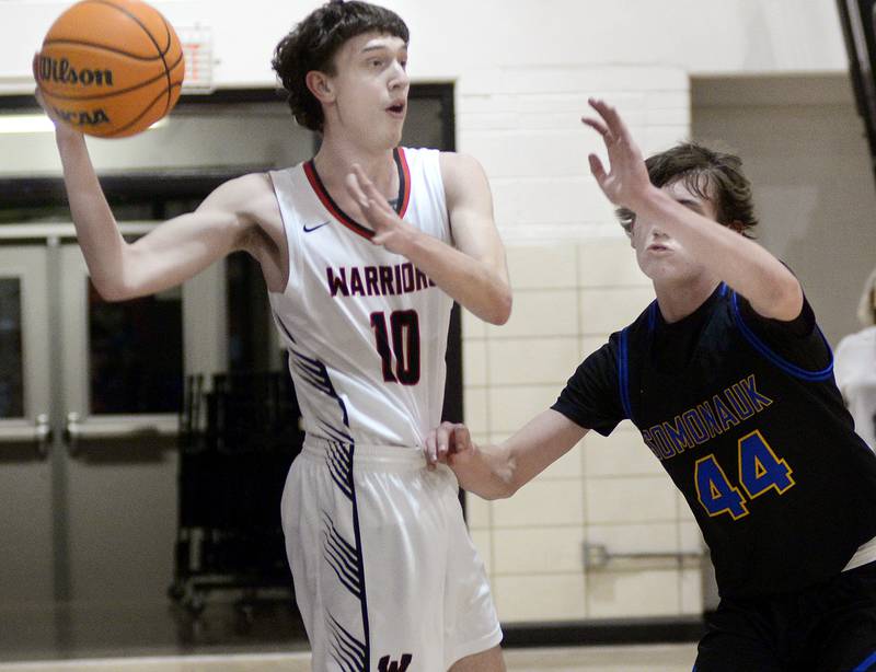 Woodland’s Jaron Follmer looks to get a pass away from the block attempt by Somonauk’s Tristan Reed in the 1st period Wednesday at Woodland.