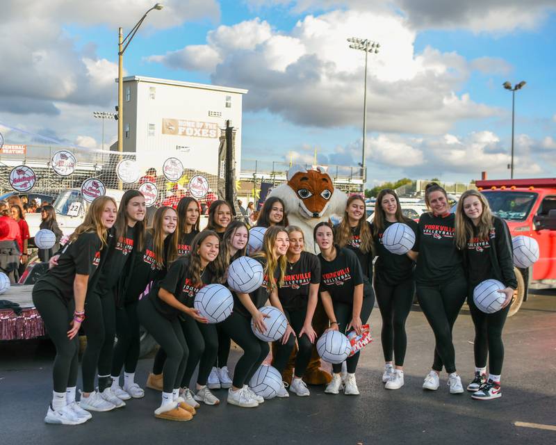 Members of the Yorkville High School volleyball team pose for a photo with the team mascot before the start of the homecoming parade held on Thursday, Sept. 28, 2023.