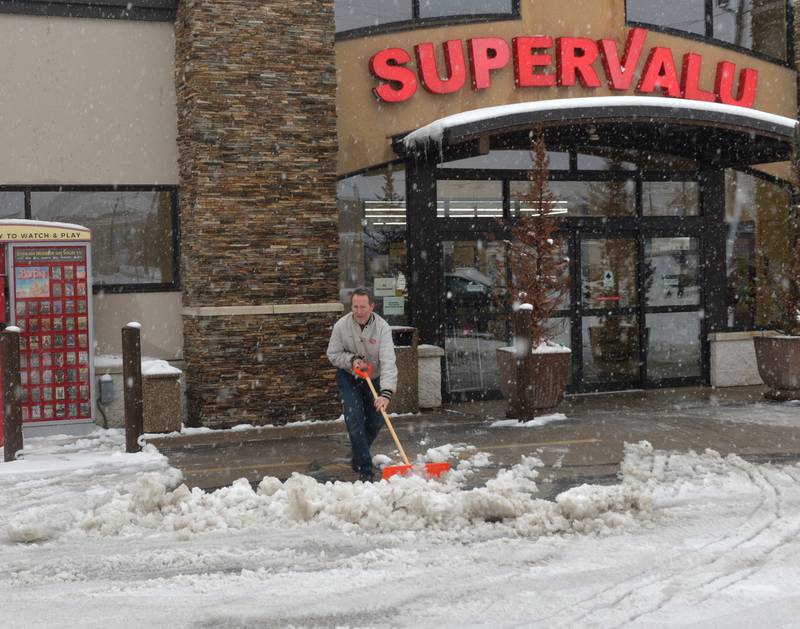 Jim Kaufman, owner of the Oregon SuperValu grocery storm in Oregon shovels in an attempt to keep the entrance of his store clear of snow on Friday, Jan. 12, 2024 . More snow was forecast throughout the region for the rest of the day and into Saturday.