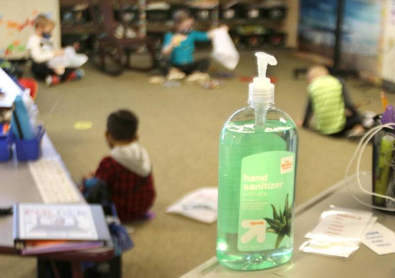 A bottle of hand sanitizer sits on a desk in a kindergarten classroom where kids work on task socially distanced from each other Wednesday at Southeast Elementary School in Sycamore. Wednesday was the first day at the school that some students were able to attend in-person classes as part of a hybrid learning plan.