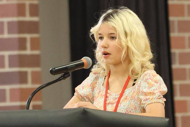Parkside Middle School student Livi Hawkins, reads her poem "I Wonder" during the Veterans Day program on Tuesday, Nov. 11, 2025 in Peru.