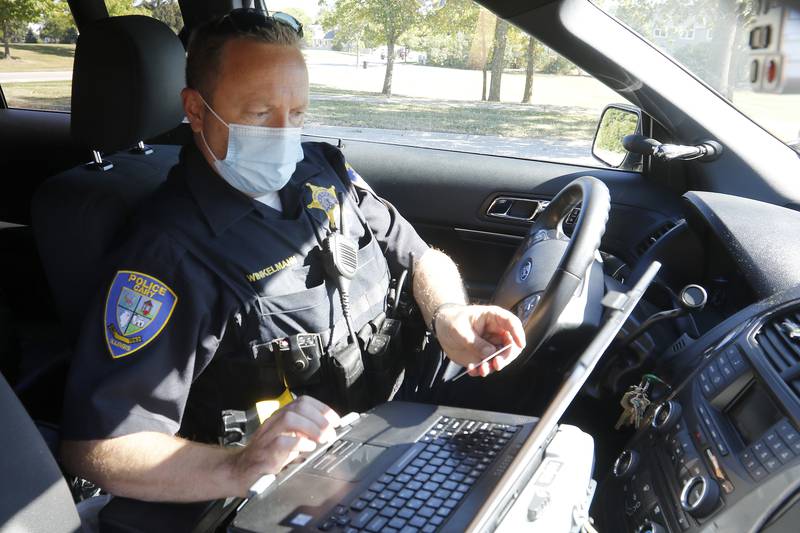 Cary Police Deputy Chief Chris Winklemann runs a drivers license after pulling a motorist over for speeding on Tuesday, Sept. 28, 2021 in Cary.  The motorist was let go with a warning.