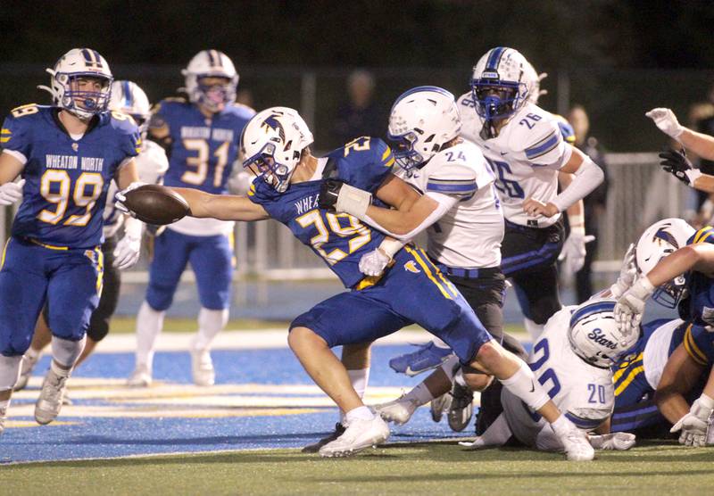 Wheaton North’s Walker Owens reaches the ball over the endzone for a touchdown during a game against St. Charles North in Wheaton on Friday, Sept. 8, 2023.