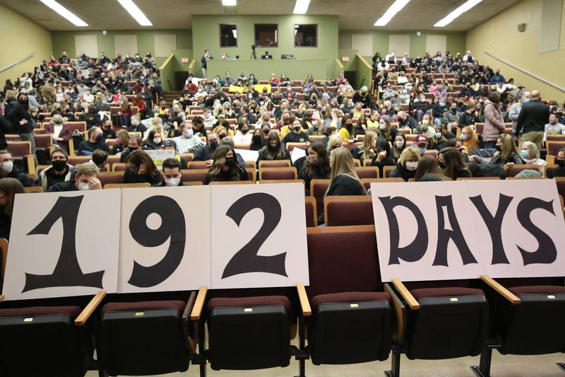 Before the Sycamore School District 427 school board meeting Tuesday, Feb. 8, 2022, a sign in the front row of the packed auditorium at Sycamore High School reflects the amount of days Sycamore teachers have been working without a contract. The meeting never began however after board president Jim Dombeck told the largely masked crowd that the meeting would be switched to a virtual format after saying several maskless individuals refused to comply with districts instruction to wear a face covering.