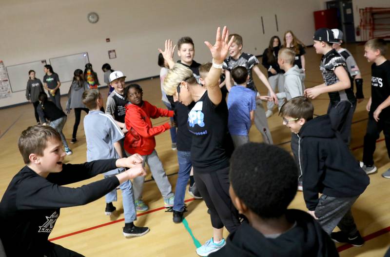 Susie Lah (center), of PoP! Power of Purpose, leads Kaneland McDole fifth graders in a dance party and celebration of a recent fundraiser at the school on Friday, March 25, 2022. Students raised over $33,000 to benefit Feed My Starving Children, A.D.O.P.T. Pet Shelter and the school’s physical education department.