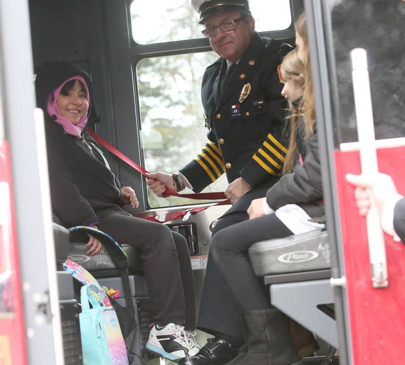 Putnam County Elementary students Priscilla Serna, Arya King and Giada Wright smile as they are seatbelted in a fire engine by deputy chief Quentin Buffington after winning the Hennepin Fire Department Escape Floor plan contest on Tuesday, Nov. 1, 2023. Students had to draw a floor plan or map of their home showing all doors and windows. Smoke alarms had to be marked in each plan. A family meeting place was also required to be marked on the drawings. The Hennepin Fire Department has been holding the contest for several years. The department stopped the event during Covid and continued it for the first time since the pandemic this year. The department picks the winning children up on a firetruck and busses them to school.