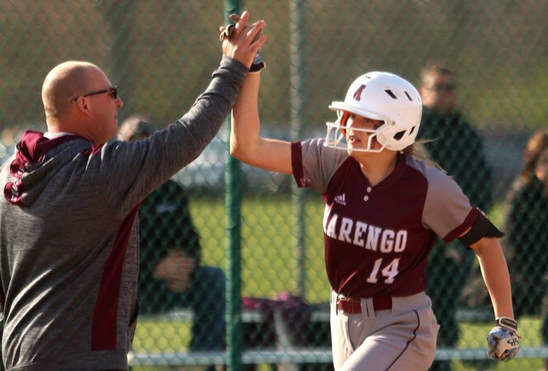 Marengo’s Kylee Jensen is greeted by head coach Dwain Nance after belting a home run against Richmond-Burton in varsity softball at Marengo Wednesday evening.