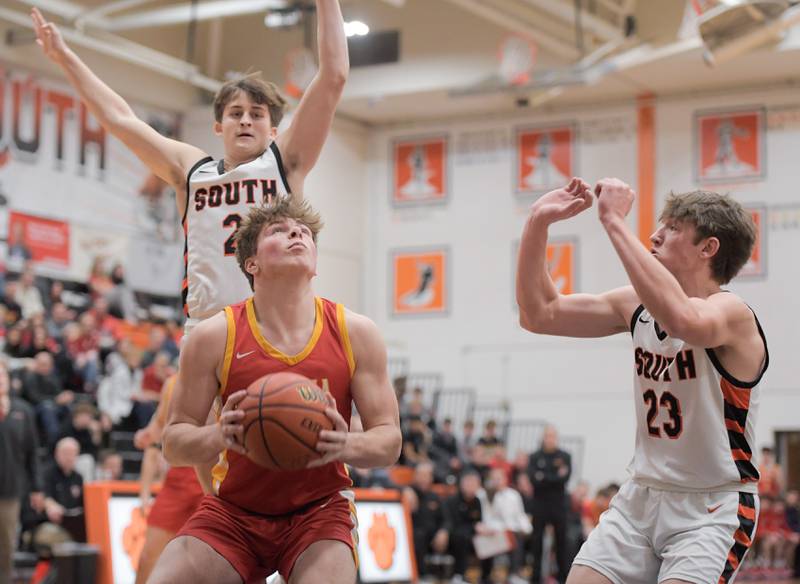 Batavia's Charlie Whelpley (22) works for the shot against  Wheaton-Warrenville South's Drew Berkley (2) and Max OÕconnell (23) during a game in Wheaton on Saturday, January 6, 2024.