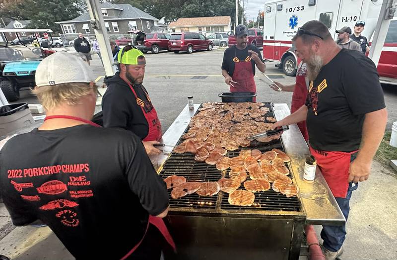Volunteers grill pork chops on the grill outside Richard Nesti Stadium on Friday, Sept. 8, 2023 in Spring Valley.. In 2022, the IHSA and the Illinois Pork Producers awarded Hall as having the best concession stand port chop sandwich in the state