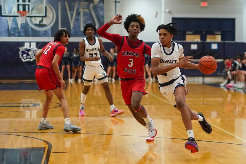 Oswego East's Mason Lockett IV (2) drives the basket against West Aurora's Jayvyn Marion (3) during a basketball game at Oswego High School on Friday, Feb 2, 2024.