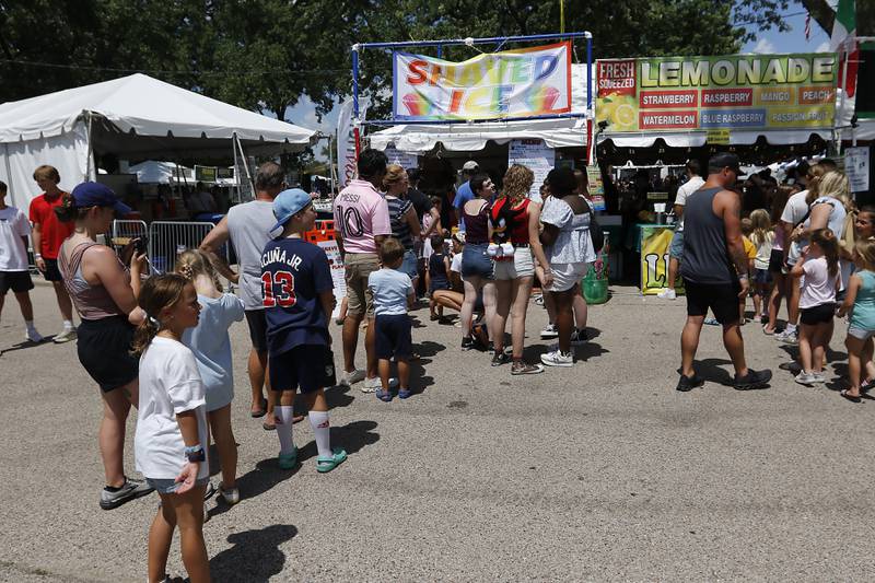 People wait  in line doe shaved ice and lemonade on Thursday, July 3, 2025, on the grounds of the historic Dole Mansion in Crystal Lake,