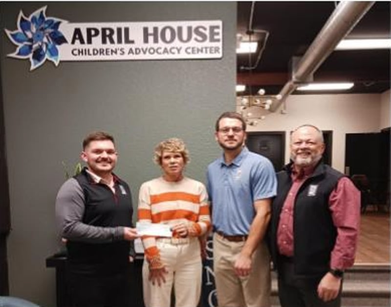 Carrie Melton of April House Children's Advocacy Center (second from left) accepts a donation from Whiteside County Bar Association members (from left) Maverik Good, Ryan Olson and Trent Bush.