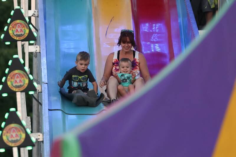 Ashley Garcia takes her two sons, Alex, 5, left, and Ethan, 2, down the slide at Lockport’s Canal Days on Friday, June 9, 2023.