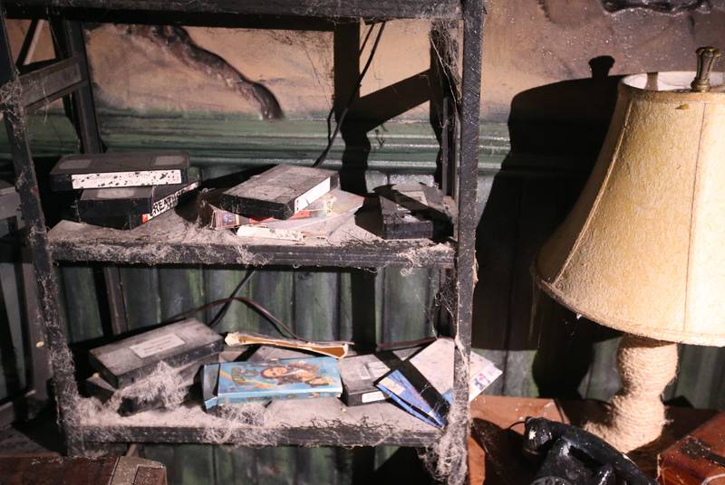 Fake dust and cobwebs cover a shelf of VHS tapes inside the Insanity Haunted House on Thursday, Oct. 3, 2024 at the Peru Mall. There is so much detail inside the haunted house and that's what sets it apart from other haunted houses throughout the State of Illinois.