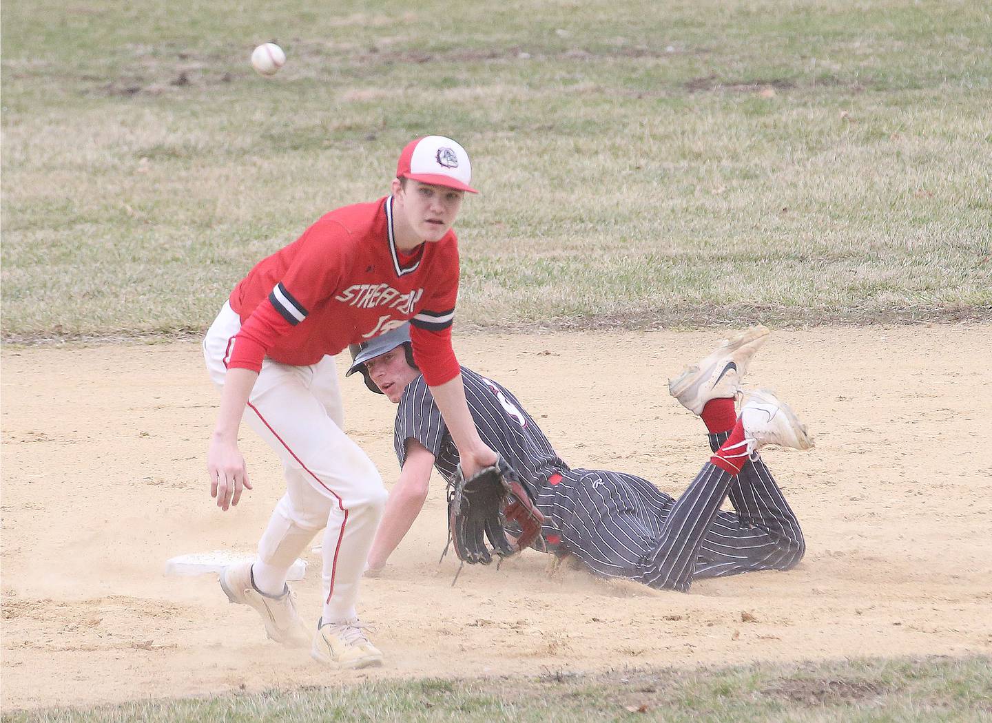 Hall's Hunter Edgcomb slides safely into second base as Streator's Blaize Bressner gathers the throw Tuesday, March 18, 2025, in Foley Field at Kirby Park in Spring Valley.