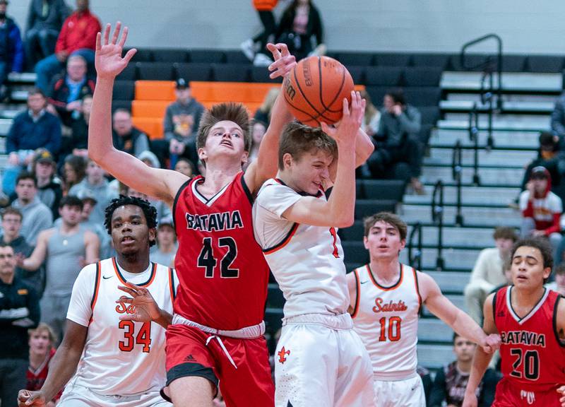 Batavia’s Austin Ambrose (42) and St. Charles East's Jack Borri (1) fight for a rebound during a basketball game at St. Charles East High School on Friday, Feb 11, 2022.