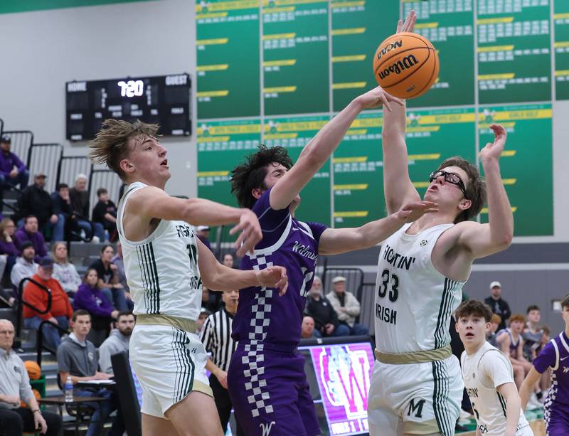 Bishop McNamara's Coen Demack, left, and Callaghan O'Connor, right, knock the ball away from Wilmington's Ryan Kettman during Bishop McNamara's 61-24 victory over Wilmington in the IHSA Class 2A Seneca Sectional semifinal on Tuesday, March 3, 2026.