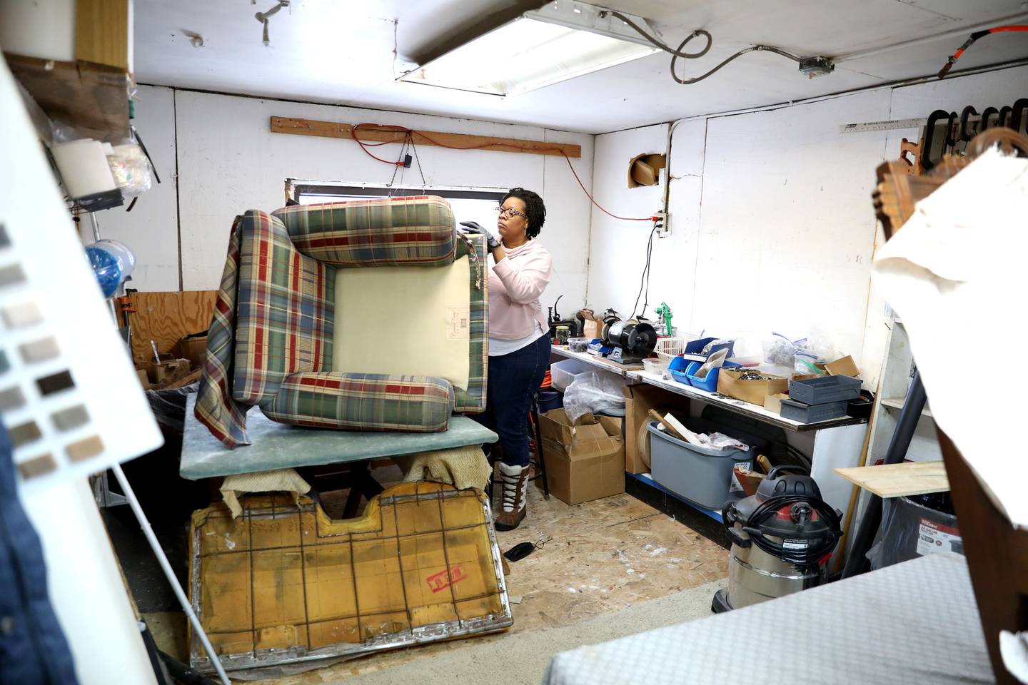 Jesseca Watson strips the old uphostery from a chair at Valley Upholstery and Design in Batavia. Following the September 2021 death of Valley Upholstery and Design owner Jesse Pitts, his family and friends, including daughter Jesseca Watson, wife Eloise and friend Ruth Scott, have been working diligently to complete his customers’ projects and keep the shop open.