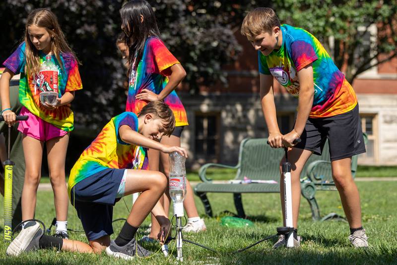 (left to right) Blake holds down rocket launcher as Griffin jumps on lever to shoot off two liter bottle rocket at the 23rd annual Carus Summer Science Camp on Friday, July 18, 2025 at St. Bede High School in Peru.