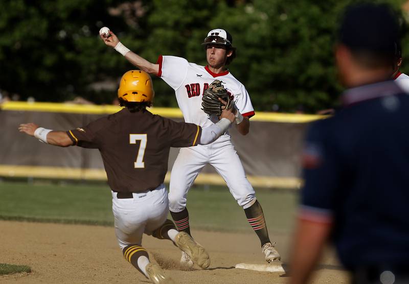 Huntley’s Lucas Goldstein throw to first to turn a double play as Jacobs's Keegan Connors slides int second base during a IHSA Class 4A baseball sectional semi-final baseball game between Jacobs and Huntley at Jacobs High School in Algonquin.