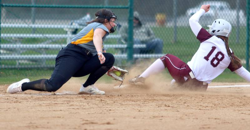 Marengo’s AJ Pollnow, right, slides safely at third base as  Harvard’s Britta Livdahl applies a tag in varsity softball at Marengo Thursday.