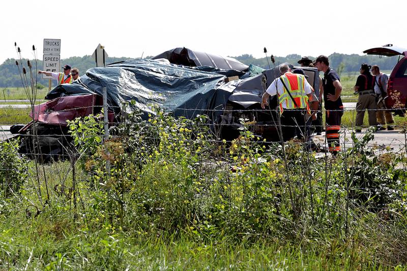 Emergency personnel use tarps to cover two vehicles while investigating a fatal accident Monday on Interstate 55 just south of mile marker 243.5 in Elwood.