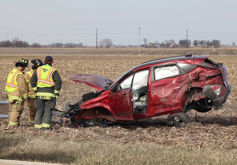 Hinckley firefighters work on a badly damaged vehicle in a cornfield on the east side of Somonauk Road south of McGirr Road Wednesday, March 25, 2026, after a two vehicle crash near Hinckley.