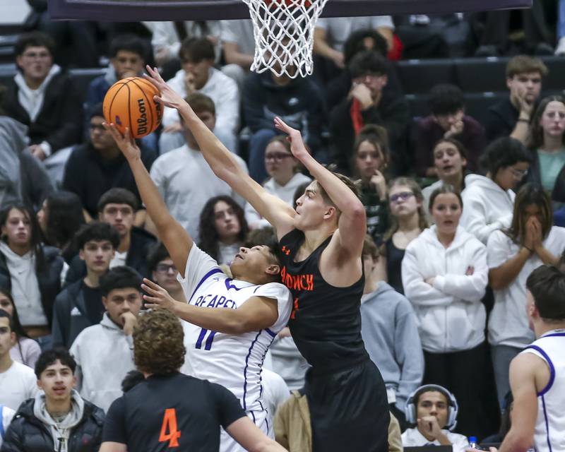 Sandwich's Ej Treptow (21) blocks a layup attempt by Plano's Matthew Herrera (11) during their basketball game between Sandwich at Plano Tuesday, Dec 9, 2025 in Plano.