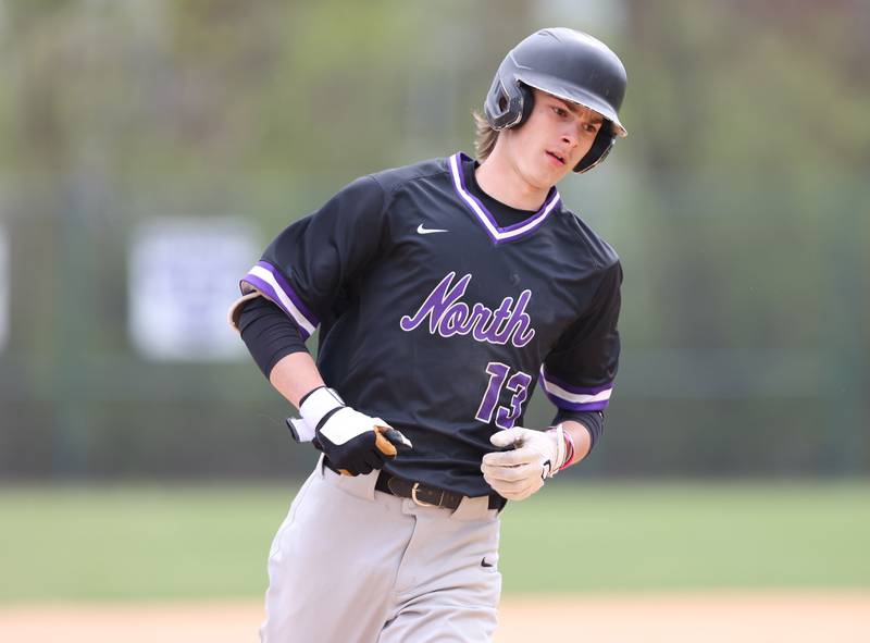 Downers Grove North's Jude Warwick (13) rounds third after his homerun during the varsity baseball game between Downers Grove South and Downers Grove North in Downers Grove on Saturday, April 29, 2023.