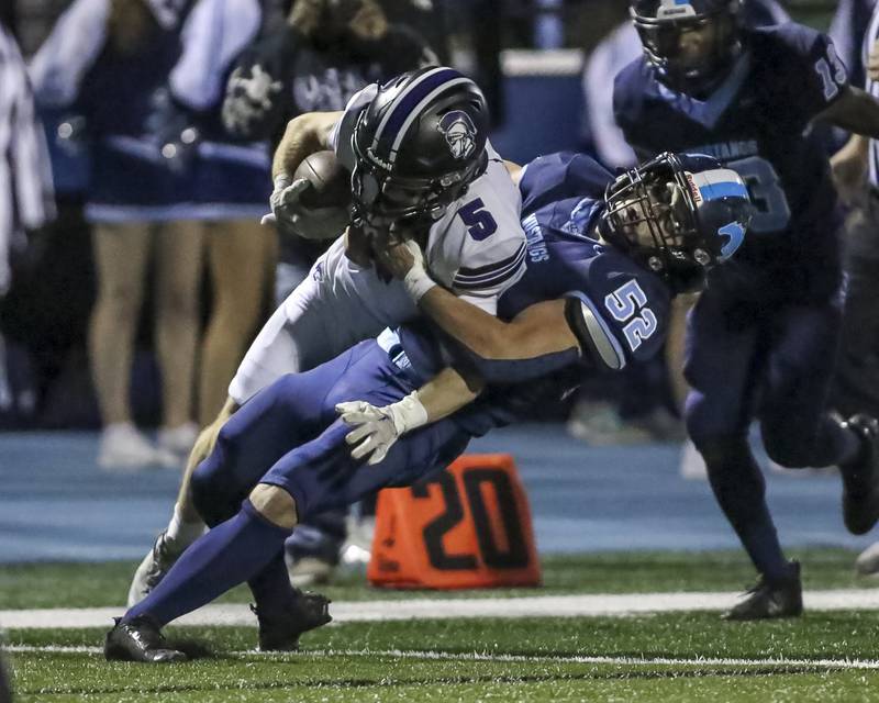 Downers Grove South's Arnas Ramanauskas (52) slams down Downers Grove North's Maxwell Troha (5) during football game between Downers Grove North at Downers Grove South Friday, Sept 5, 2025  in Downers Grove.