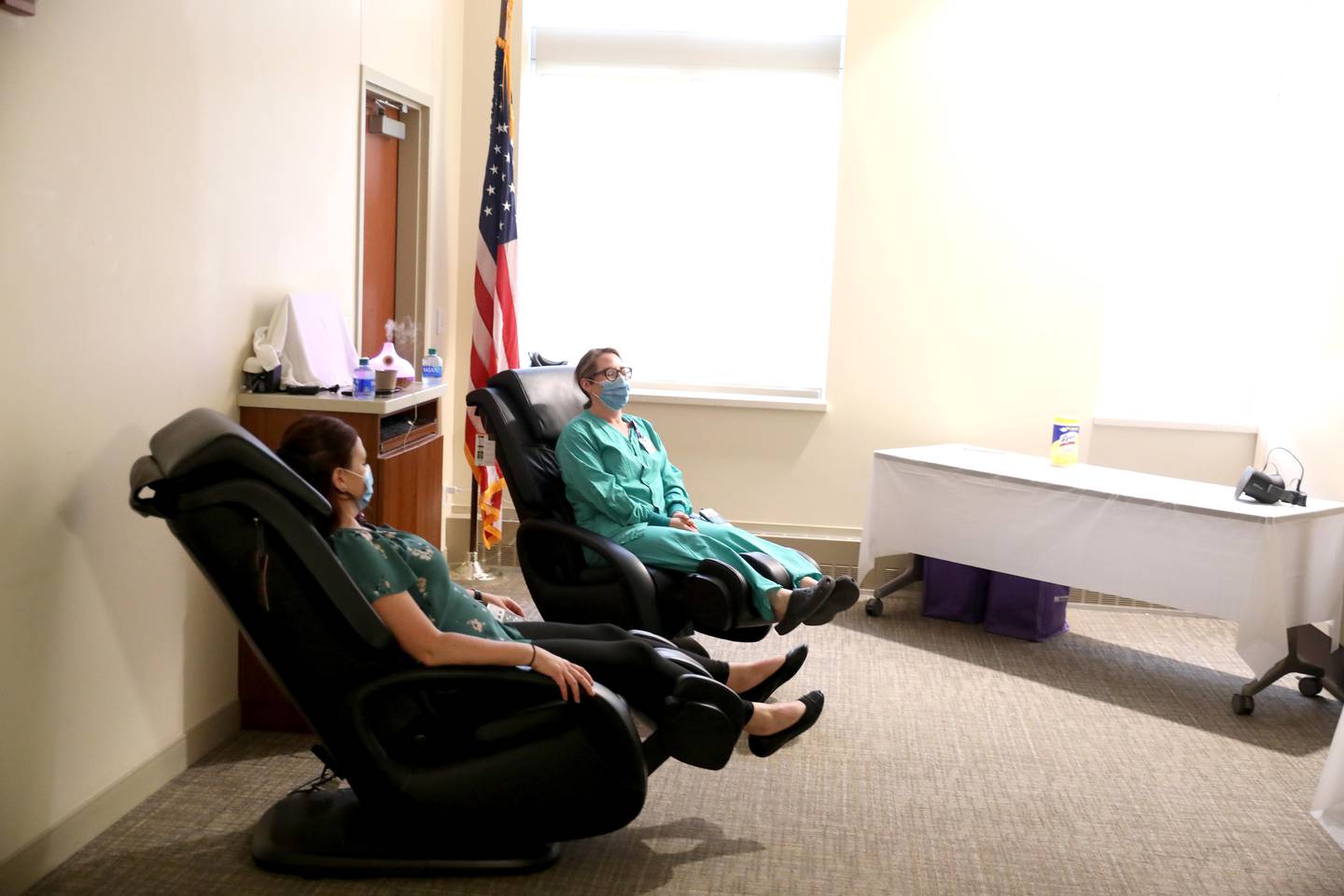 Las enfermeras registradas Laura Wilson (izquierda) y Meg Pittard se relajan en sillones de masaje como parte de una celebración de la Semana Nacional de Enfermeras en el Hospital Northwestern Medicine Delnor el miércoles 11 de mayo de 2022.