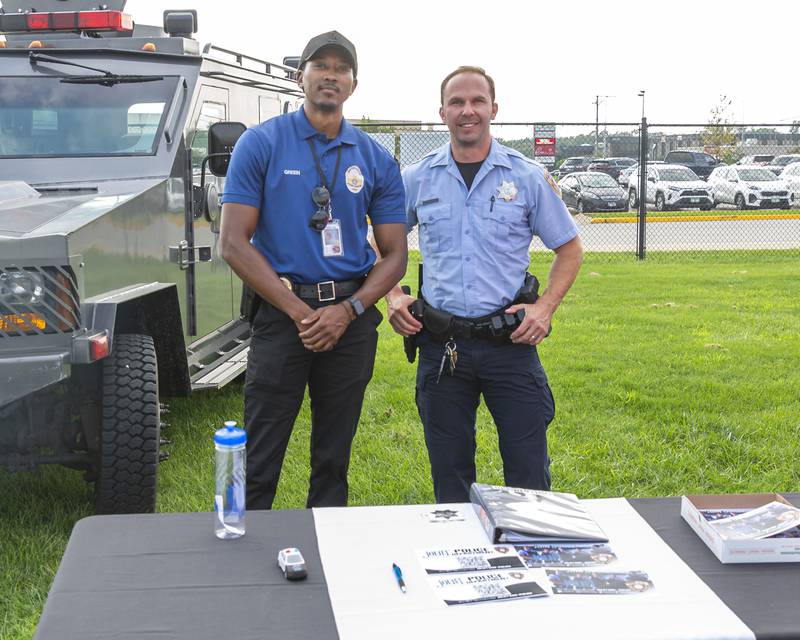 Detective EJ Green (L) and Officer Mark Sousek man the recruiting table at the Joliet Police Department's National Night Out event Tuesday, Aug 5, 2025  in Joliet.