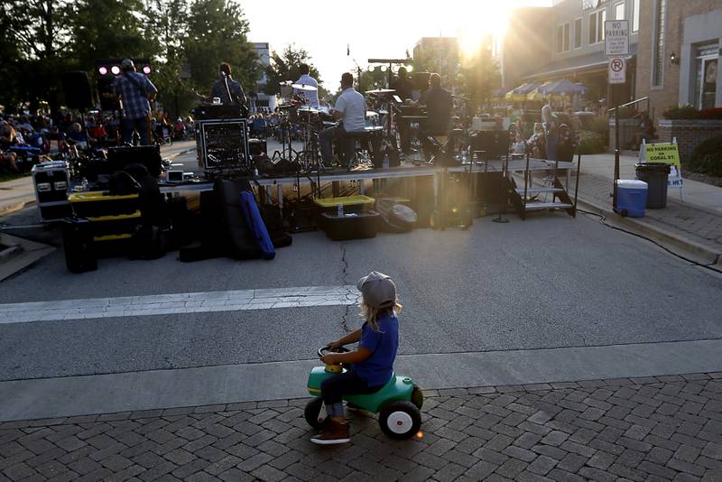 A boy rides is tractor behind One of These Nights, an Eagles tribute band, as they perform on Tuesday, Aug. 8 2023, during Huntley’s weekly Concert on the Square. I like this image because the way the boy stops behind the band just feels like a Eagles song to me.