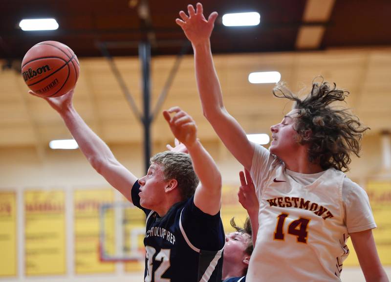 IC Catholic's Andrew Hill snags a rebound as Westmont's Billy McGhie (14) defends during a game on Jan. 5, 2024 at Westmont High School in Westmont.