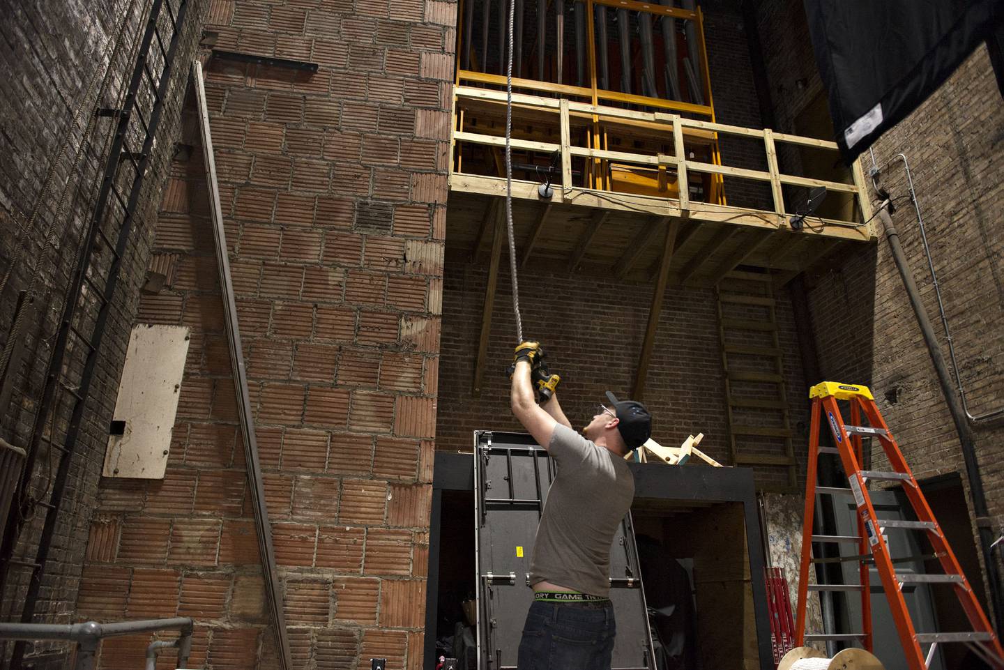 Spencer Aurand sends equipment to the rafters where Scott Shipp is working. The new ownership is dedicated to making the theater a top-notch entertainment facility once again.