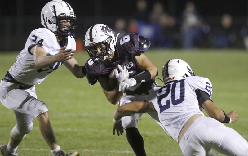 Cary-Grove's Jack Rocen, left, and Conner Anderson, right, try to tackle Prairie Ridge's Luke Vanderwiel during a Fox Valley Conference football game between Prairie Ridge  and Cary-Grove Friday, Sept. 23, 2022, at Prairie Ridge High School in Crystal Lake.