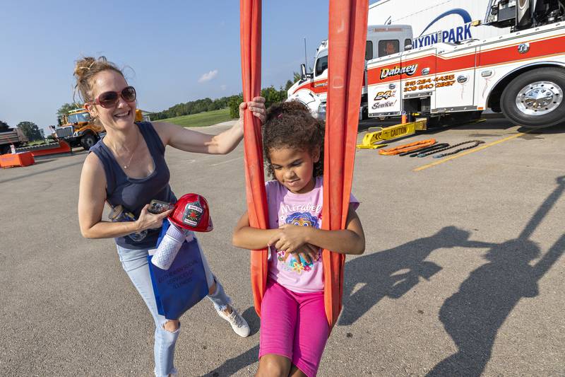 Aaliyah Kimble, 6, gets pushed mom Stephanie Tuesday, August 5, 2025, on swing set up by Dabney Towing during Dixon’s National Night Out celebration.