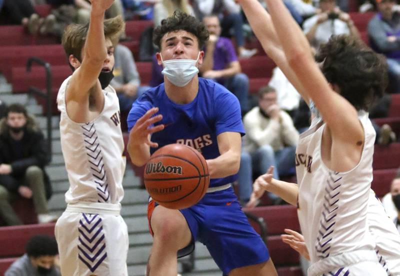 Genoa-Kingston's Alec Golembiewski gets to the basket between two Wauconda defenders Thursday, Dec. 23, 2021, during the championship game of the 71st Annual E.C. Nichols Holiday Classic Basketball Tournament at Marengo High School.