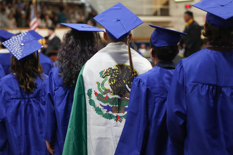 A graduate wears the Mexican flag as he stands to receive his diploma at the Joliet Central Class of 2023 Commencement Ceremony on Saturday, May 20, 2023, in Joliet.
