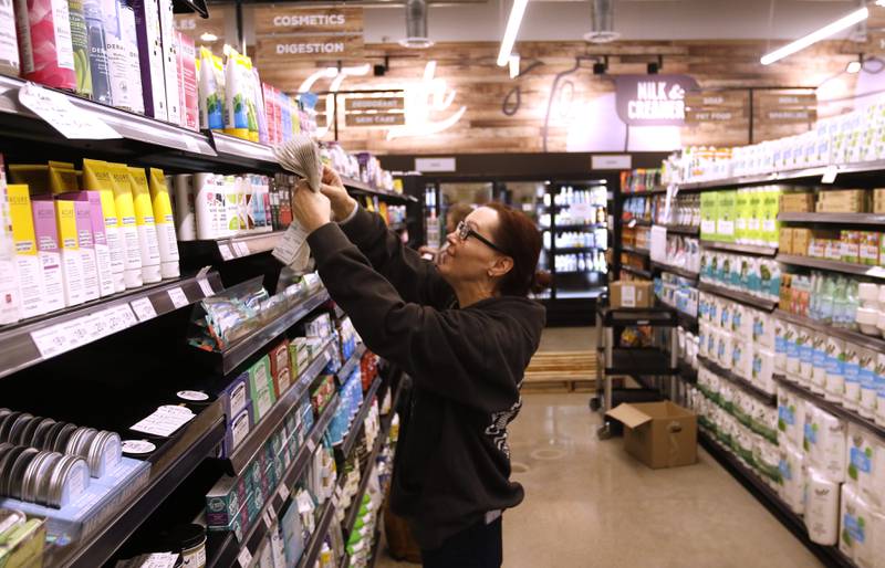 Julie Hafer with National Co+op Grocers, helps price items at the Food Shed, McHenry County's first co-op grocery store, on Friday, May 10, 2024, as the store prepares to open on May 15.
