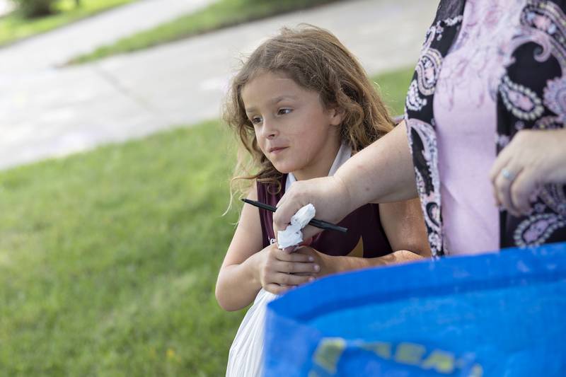 Malaina Herrera, 7, of Dixon, takes a bag of lunches Wednesday, July 16, 2025, from Tina Adcock as part of the United Way of Lee County Summer Eats program. Each bag contains three lunch items plus a breakfast food.