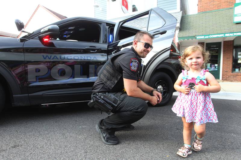 Conrad Sek, police officer with the Wauconda Police Department, gave a sticker to Annabelle Middleton, 2, of Wauconda during National Night Out on Main Street on Tuesday, August 1st in Wauconda.  
Photo by Candace H. Johnson for Shaw Local News Network.