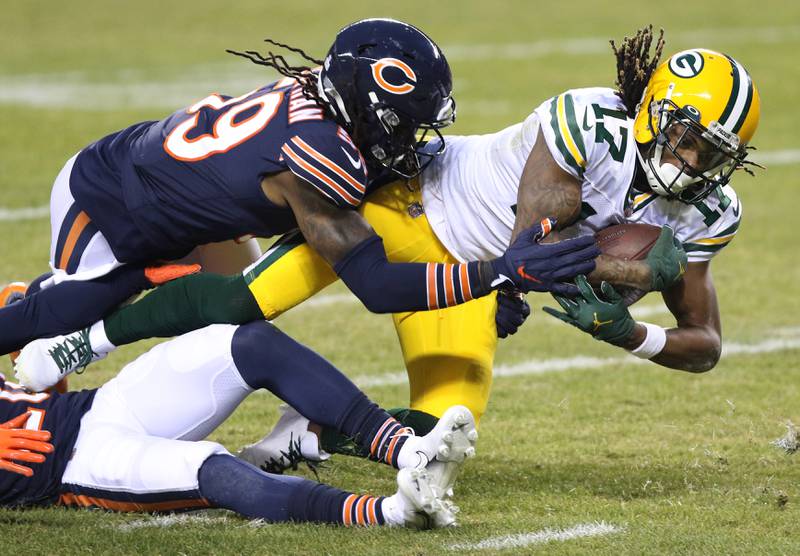 Green Bay Packers wide receiver Davante Adams (17) stretches for extra yardage as Chicago Bears inside linebacker Danny Trevathan (59) and Chicago Bears cornerback Duke Shelley (20) bring him down during their game Sunday at Soldier Field in Chicago.